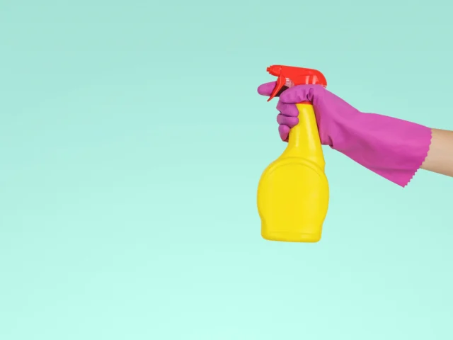 Cleaner holding a yellow spray bottle