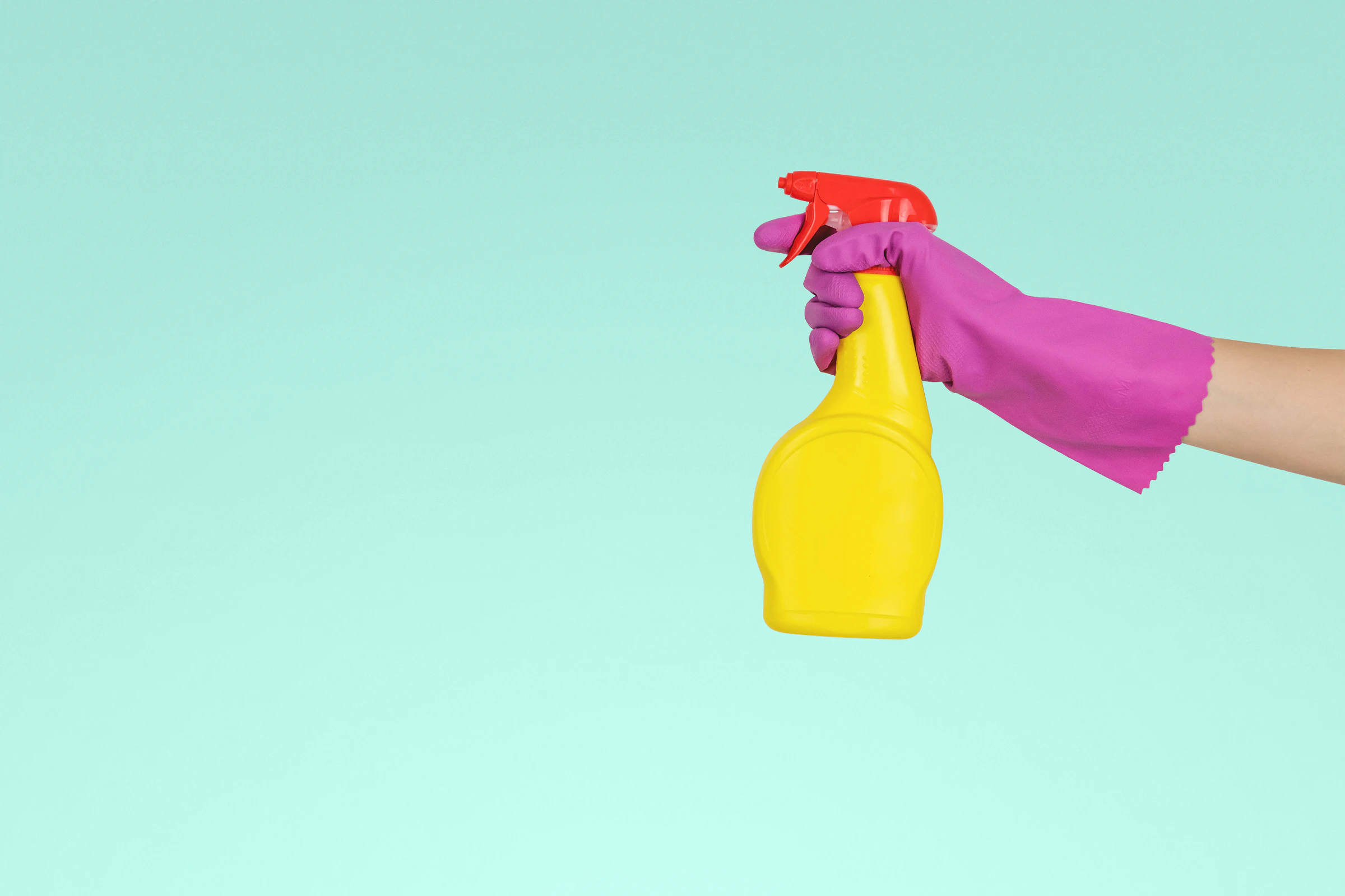 Cleaner holding a yellow spray bottle