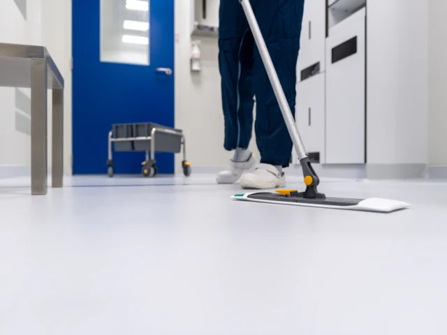 Cleaner mopping a bright commercial corridor