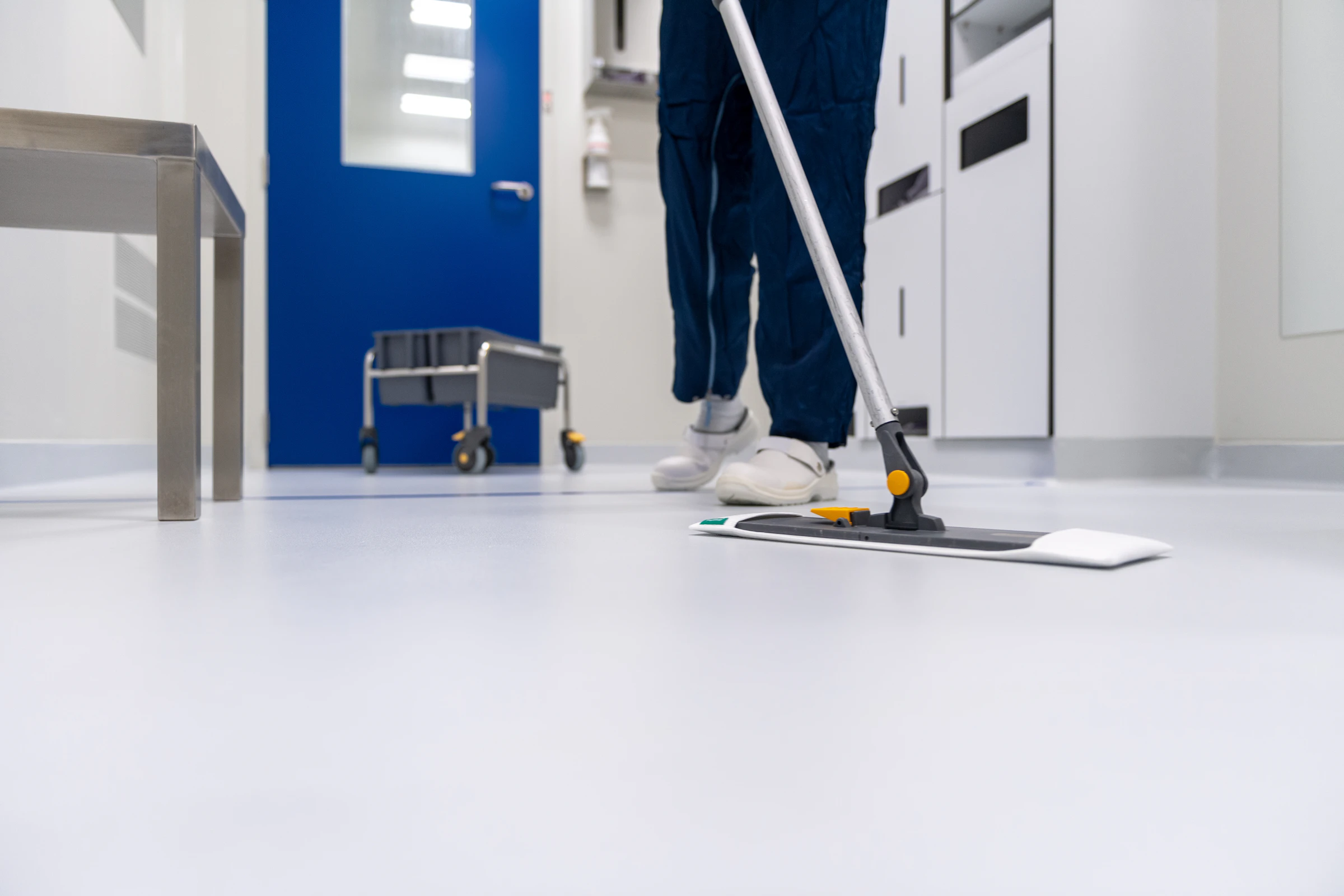 Cleaner mopping a bright commercial corridor