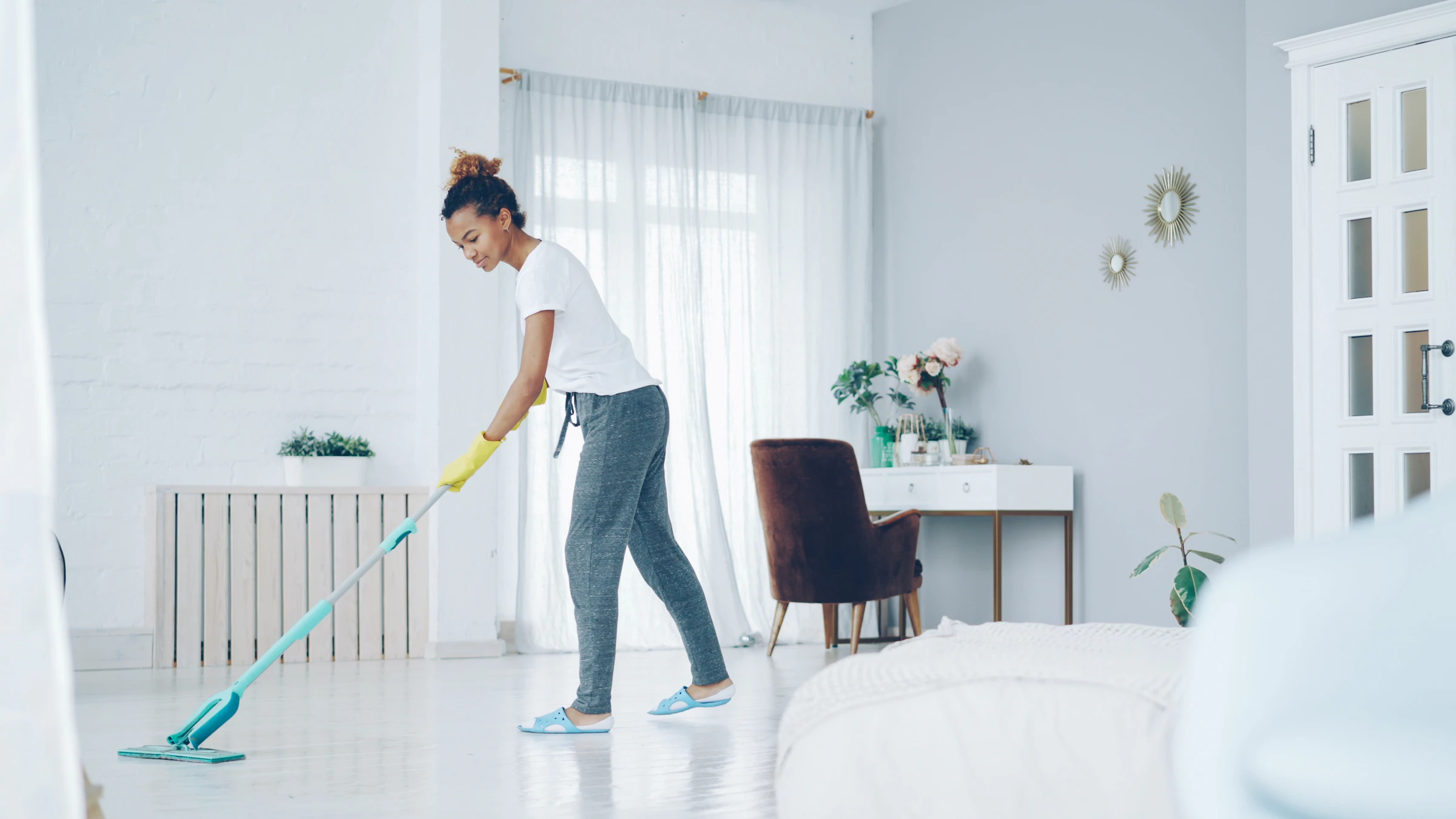Cleaner mopping a bright living room floor