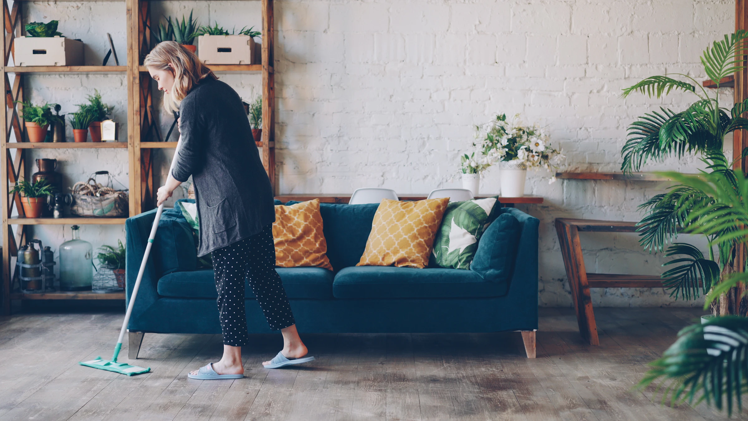 Cleaner mopping the floor of a modern living room