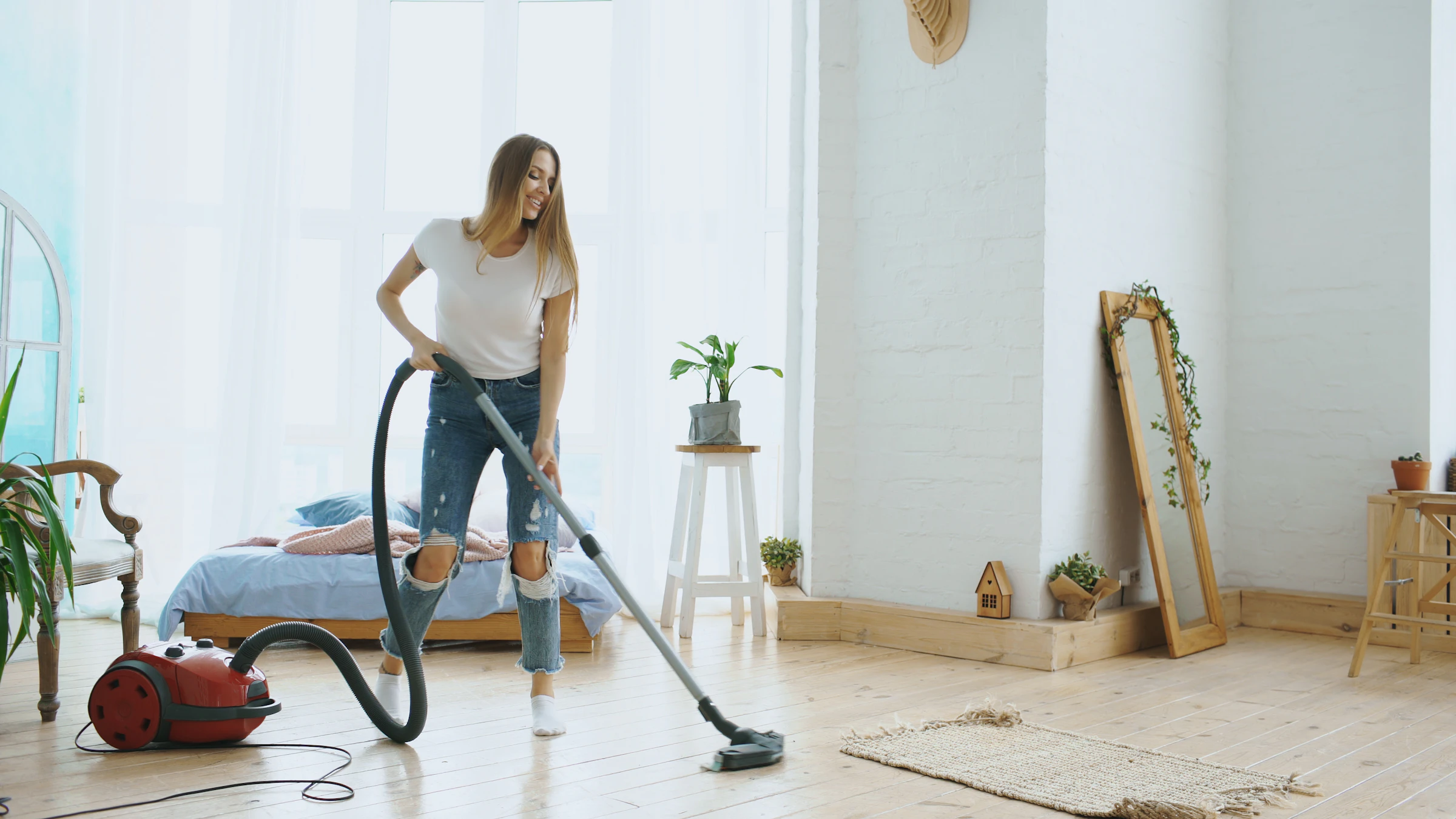 Cleaner vacuuming a bright living room