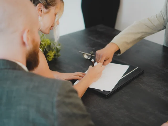 Couple signing a document at a desk