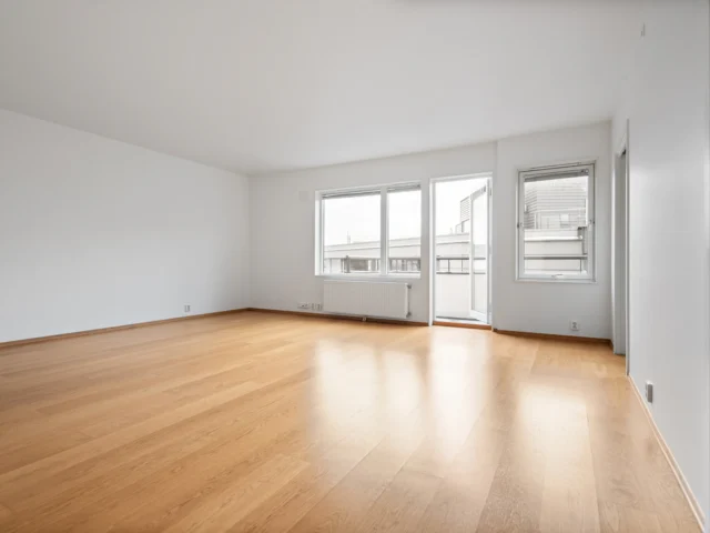 Empty room with wooden floors and white walls