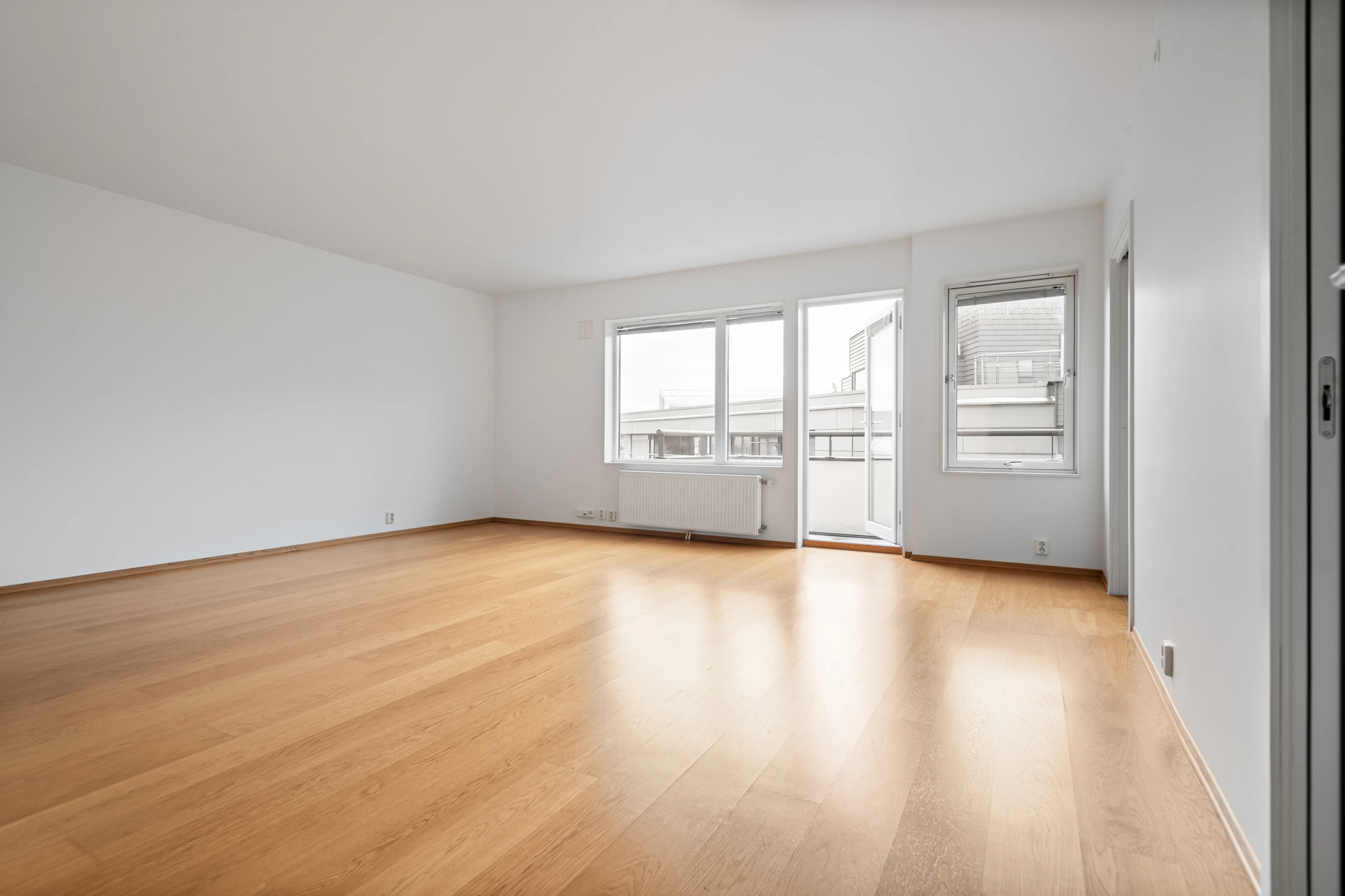 Empty room with wooden floors and white walls