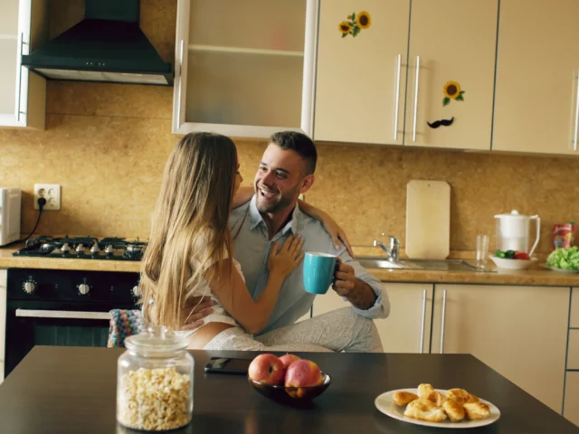 Housemates having coffee in a bright shared kitchen