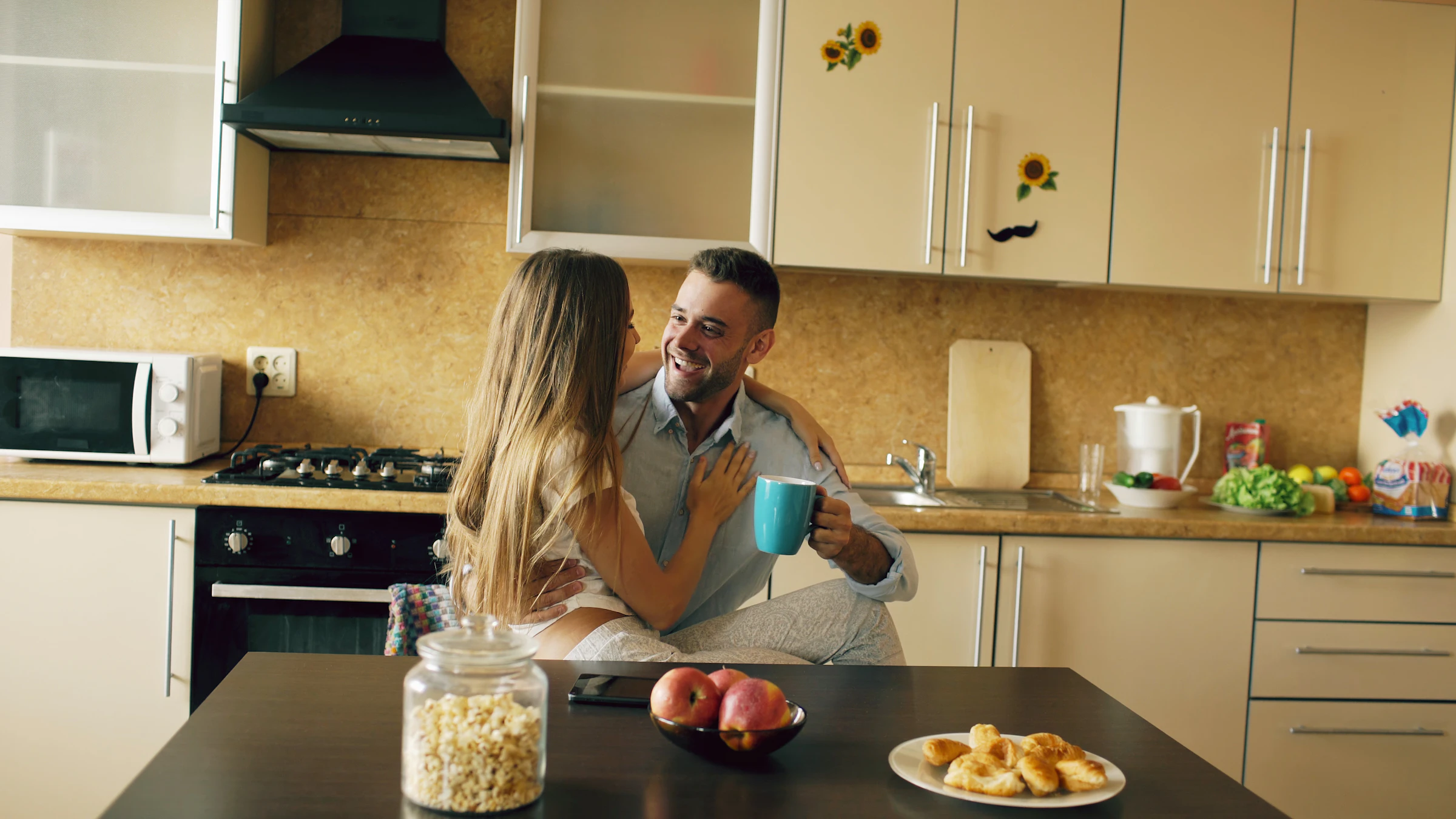 Housemates having coffee in a bright shared kitchen