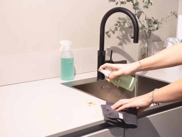 Kitchen sink being scrubbed clean with a cloth