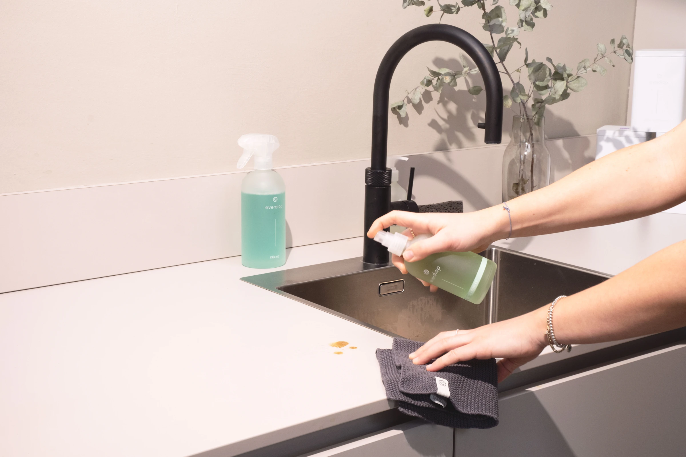 Kitchen sink being scrubbed clean with a cloth