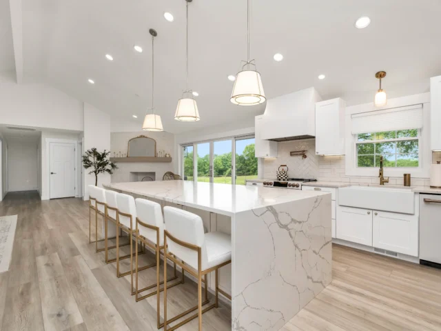 Large kitchen with a marble island and white cabinets