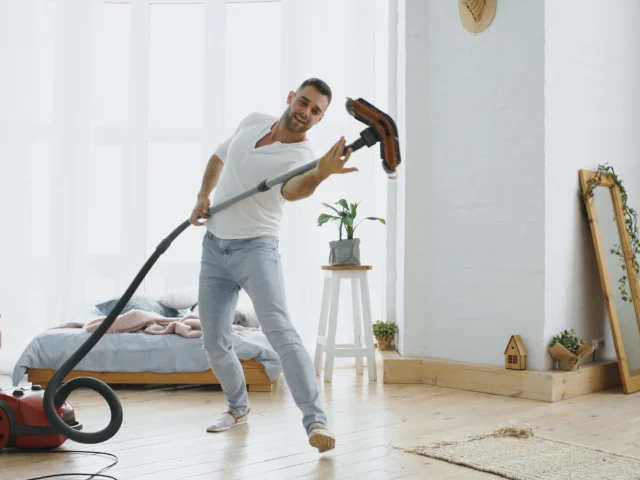 Man vacuuming in a bright room