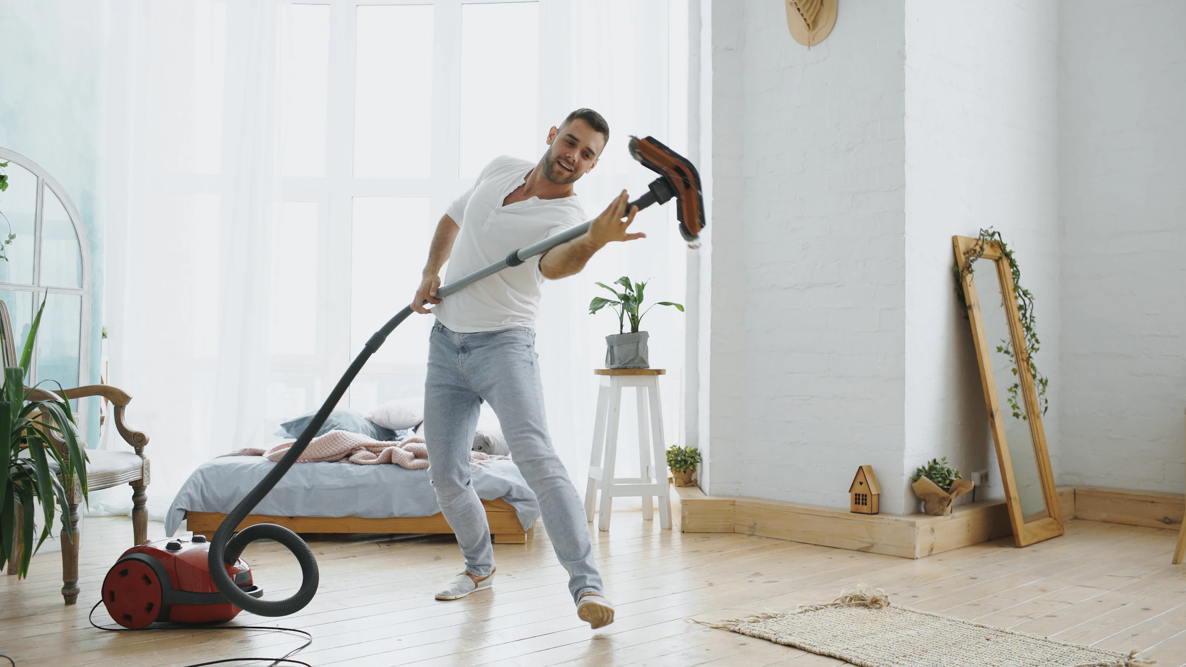 Man vacuuming in a bright room