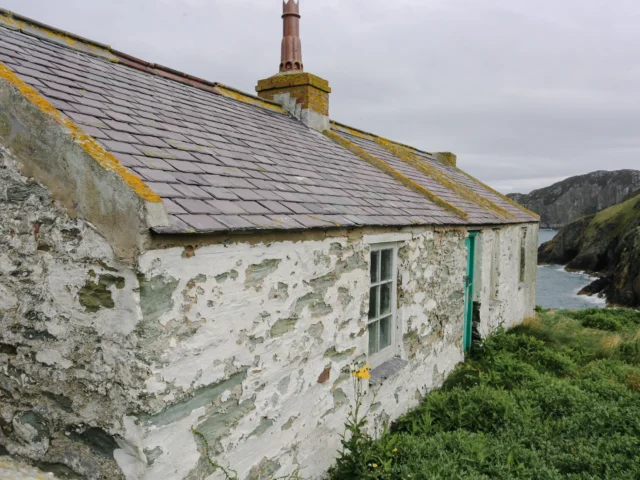 Old stone cottage by the sea on a cloudy day