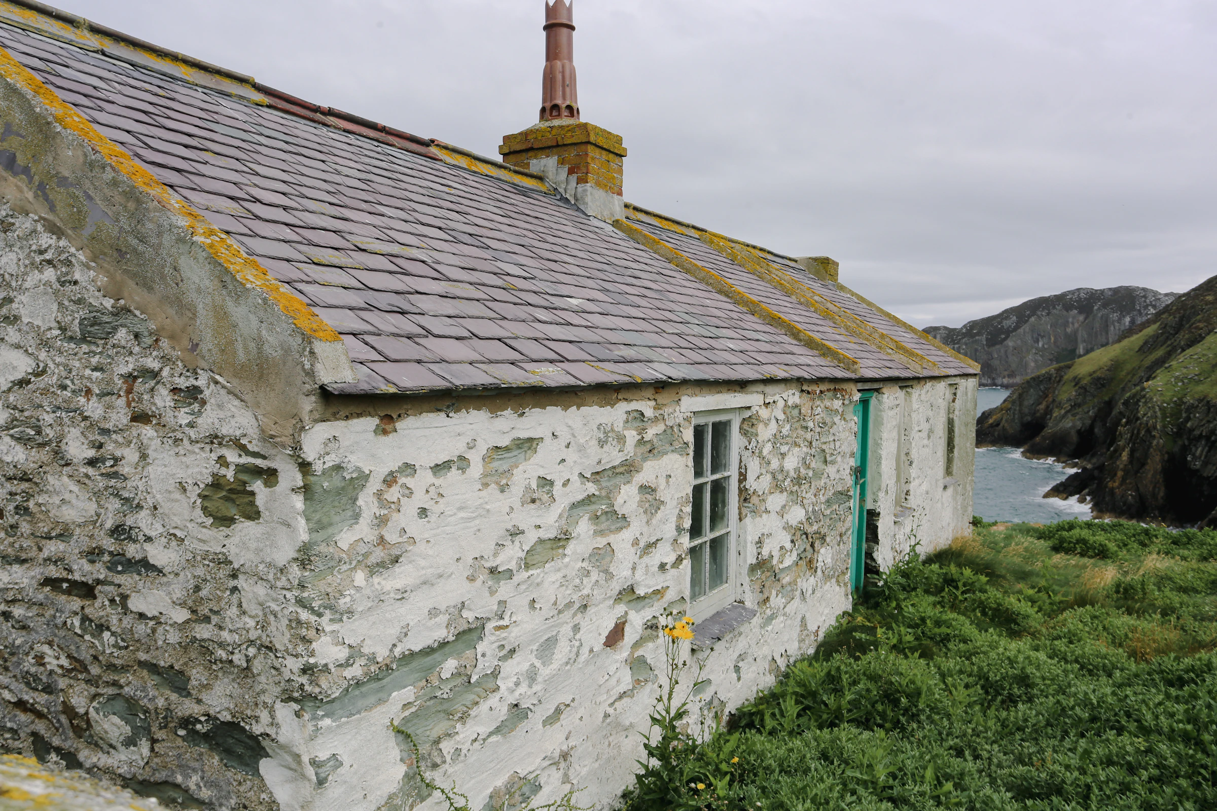 Old stone cottage by the sea on a cloudy day