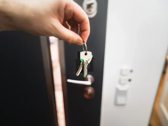 Person holding a key to a front door