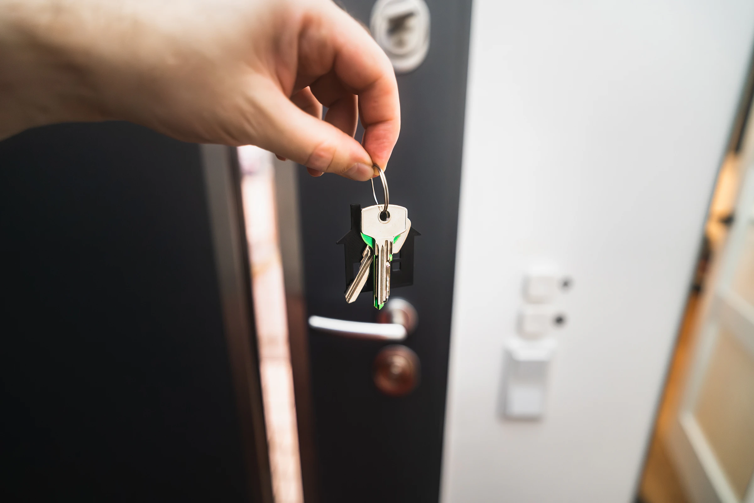 Person holding a key to a front door