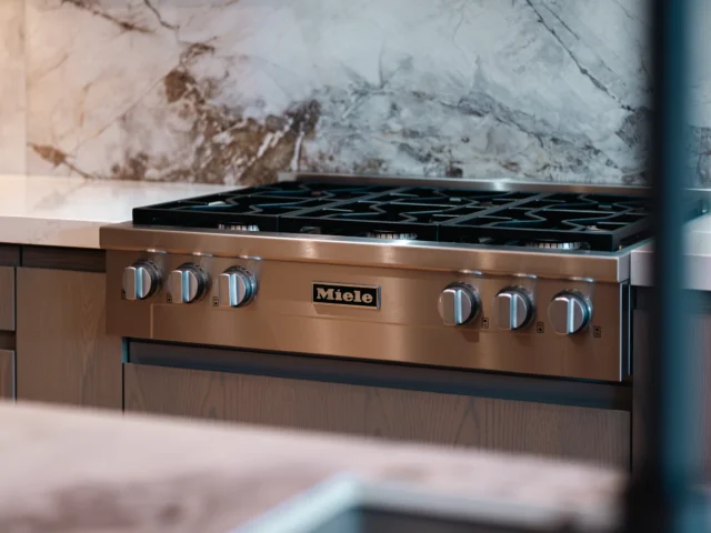 Stainless steel range cooker with a marble splashback