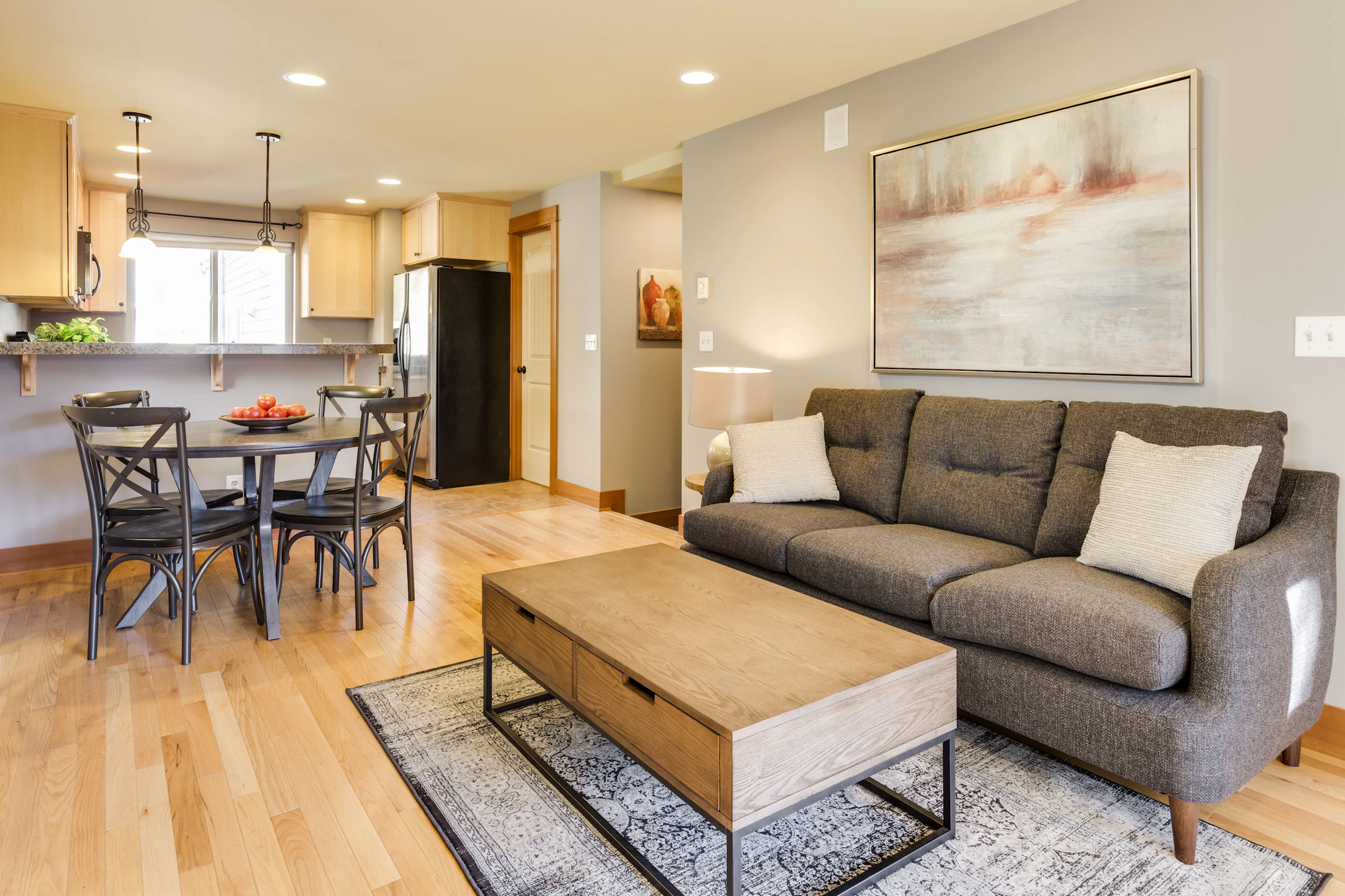 Wooden coffee table and grey three-seat sofa in a finished room
